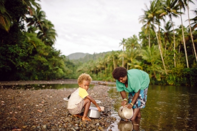 A woman cleans her pots in a river while her child watches. (Department of Foreign Affairs and Trade)  [flickr.com]  CC BY 
Informazioni sulla licenza disponibili sotto 'Prova delle fonti di immagine'